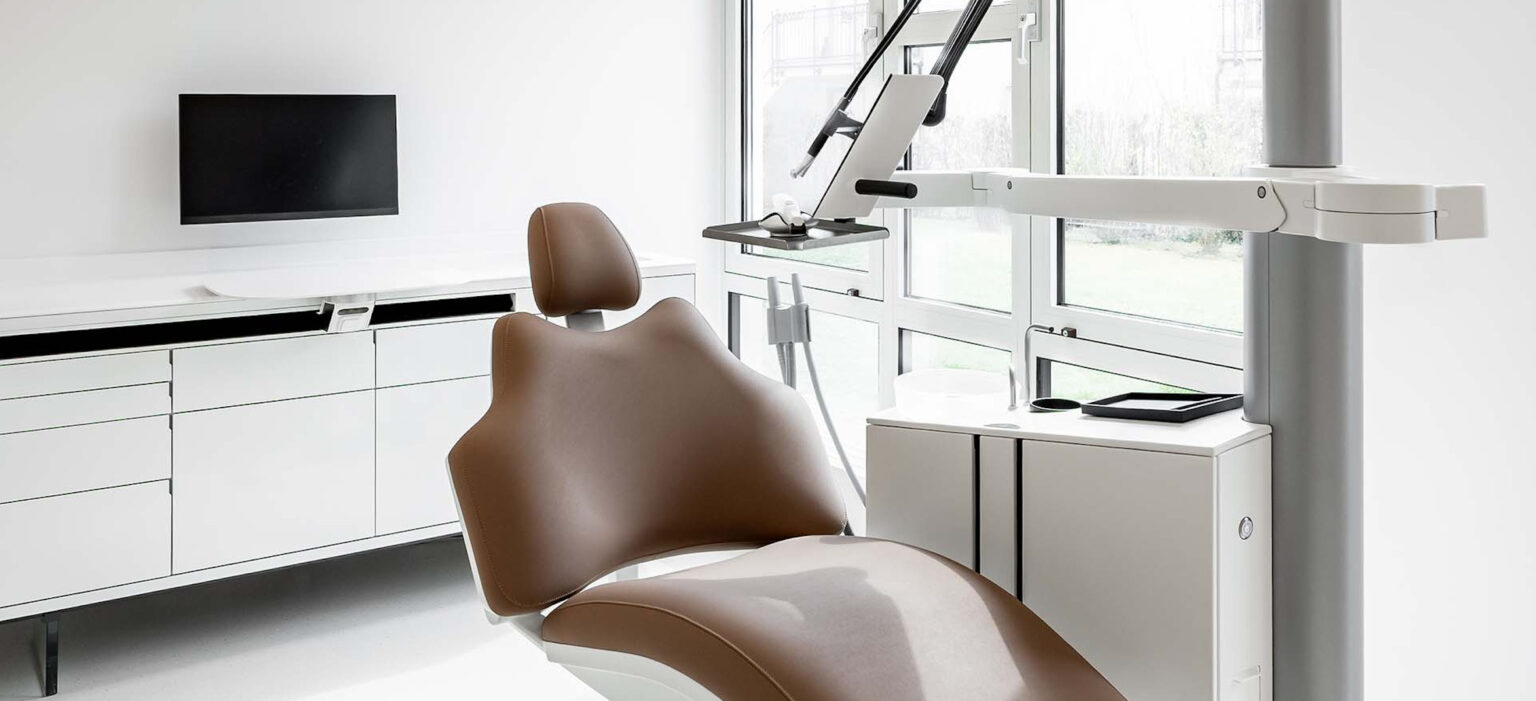 Helle, weiße Behandlungskabine im LIV*dental studio in Deisenhofen mit moderner Technologie, klaren Linien und ruhiger Atmosphäre.